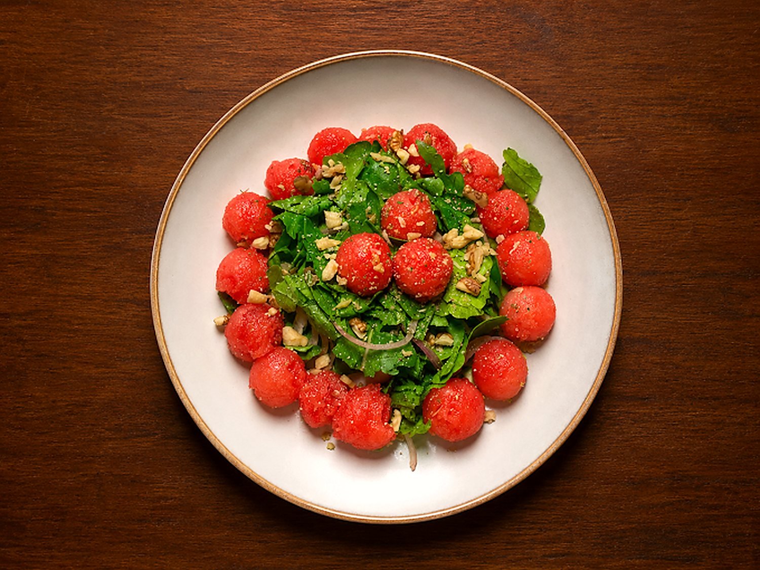 Watermelon, rocket and toasted nuts on a wide plate