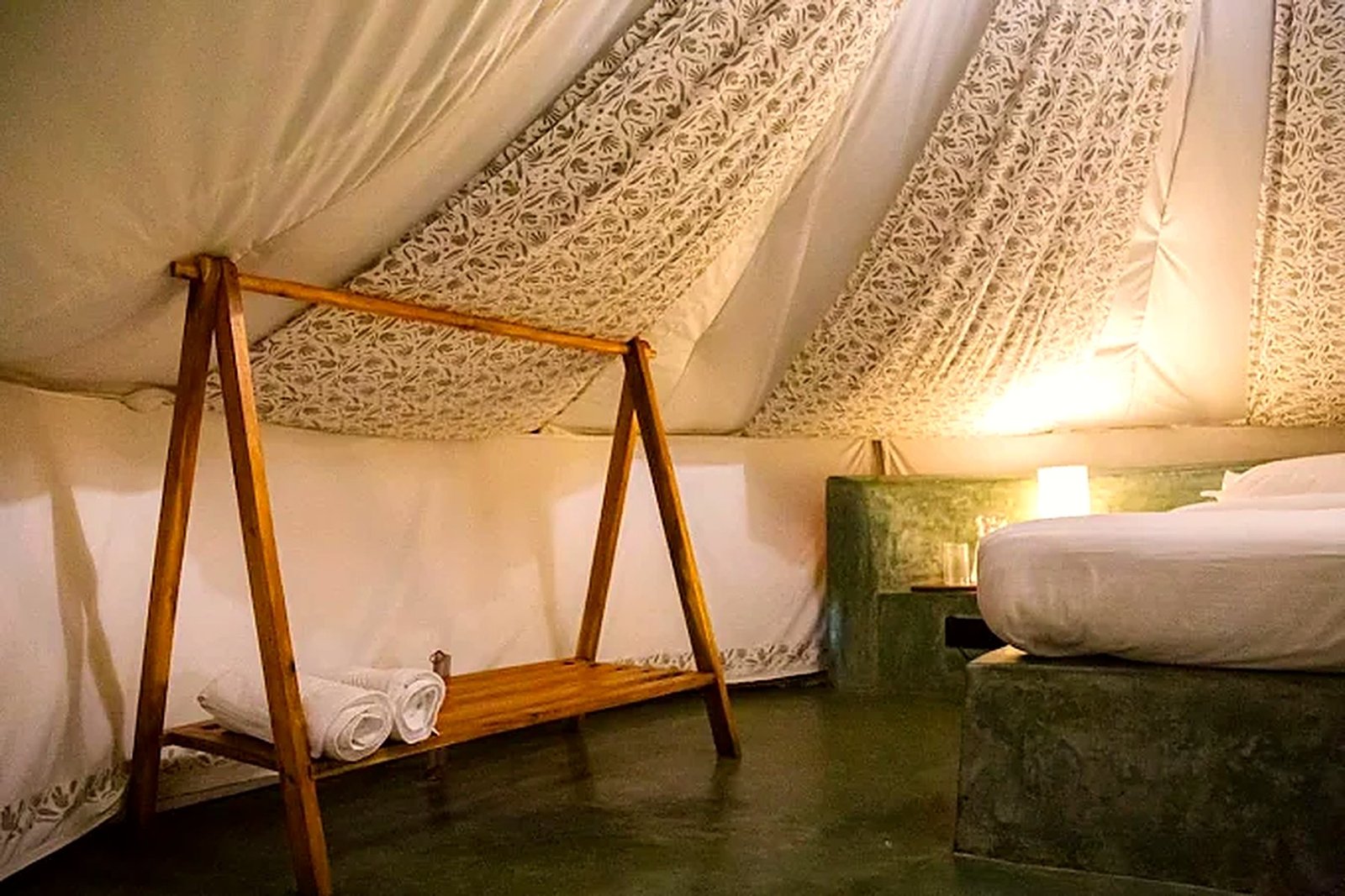Inside a Virama tent, with a canvas ceiling, a lime plaster bed base and a teak rack